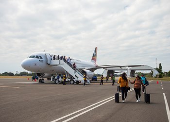 Passengers Disembark A Plane Upon Arrival At Presidente Nicolau Lobato International Airport In Dili, Timor Leste. The Airport Is The Largest In Timor Leste
